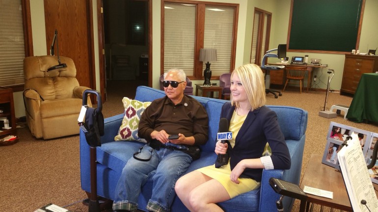 Milton Ota demonstrates the built-in accessibility features on his iPhone to anchor Becky Parker.