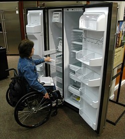 Woman in wheelchair checking out a fridge