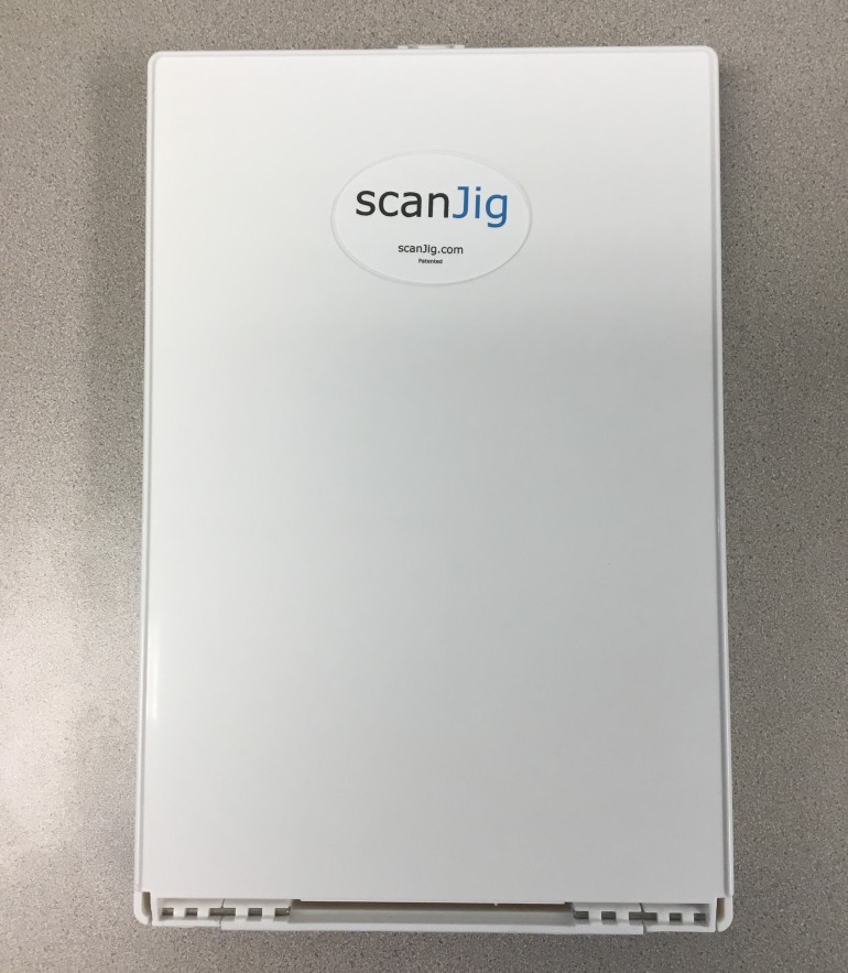 ScanJig - white, rectangular unit a little larger than a sheet of paper. About 3 inches deep.