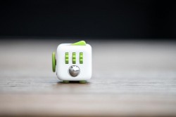 A fidget Cube From Antsy Lab in whte and lime greens