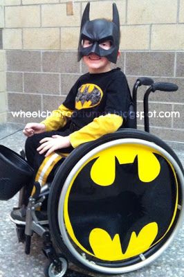 Photo of a child in a wheelchair disguised as Batman.