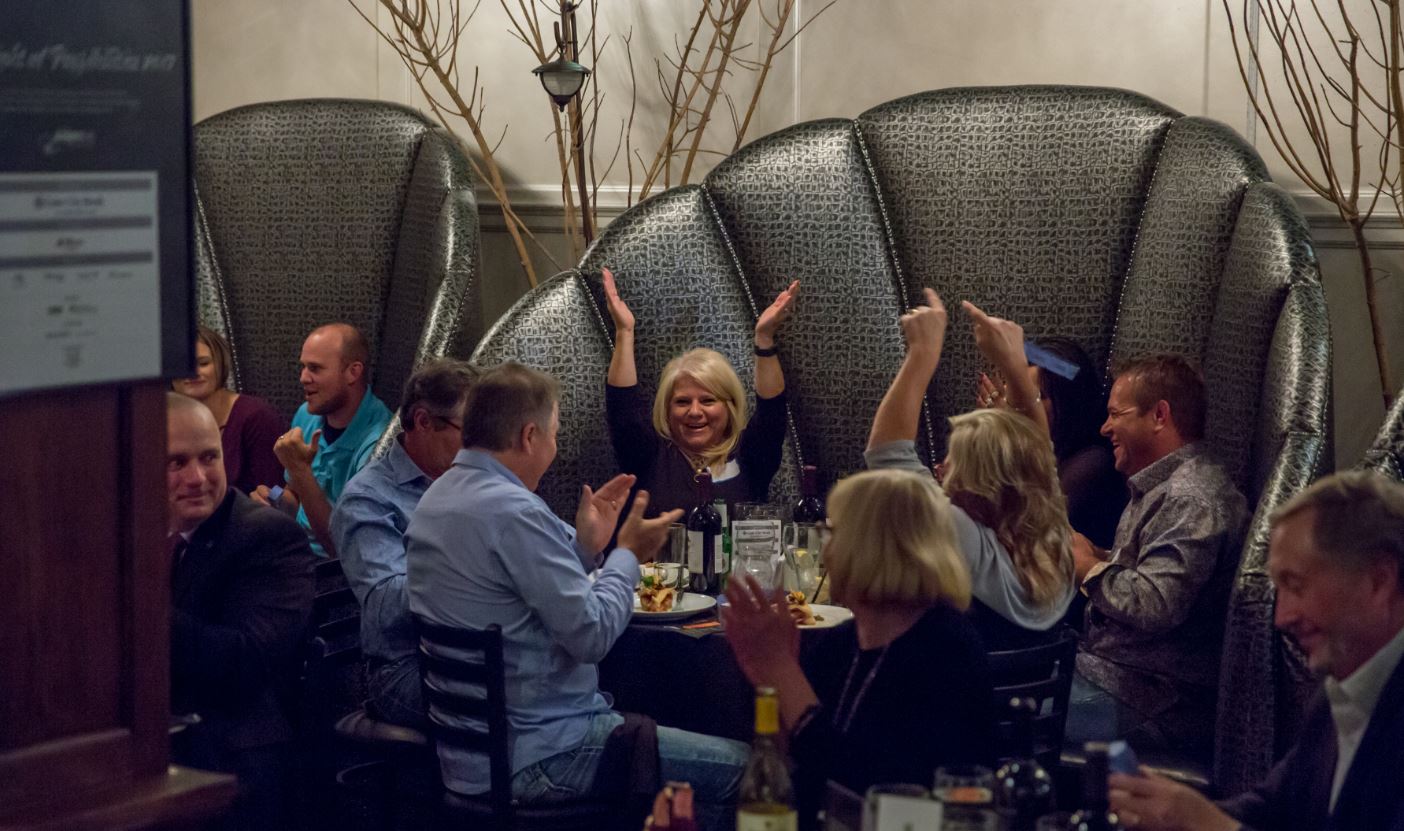 Table of people celebrating because they won a raffle ticket item.