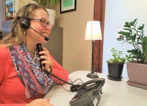 A woman using the TeliTalk Phone with a Headset