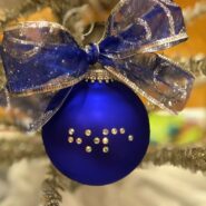 Blue Christmas ball hanging on a tree with crystals spelling out Hope in Braille