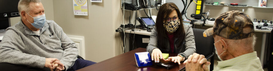 Image of ND Assistive staff helping a client with receiving and using a phone.