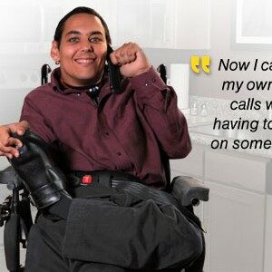 Man in wheelchair smiling. Quote that states, "Now I can make my own phone calls without having to depend on someone else."