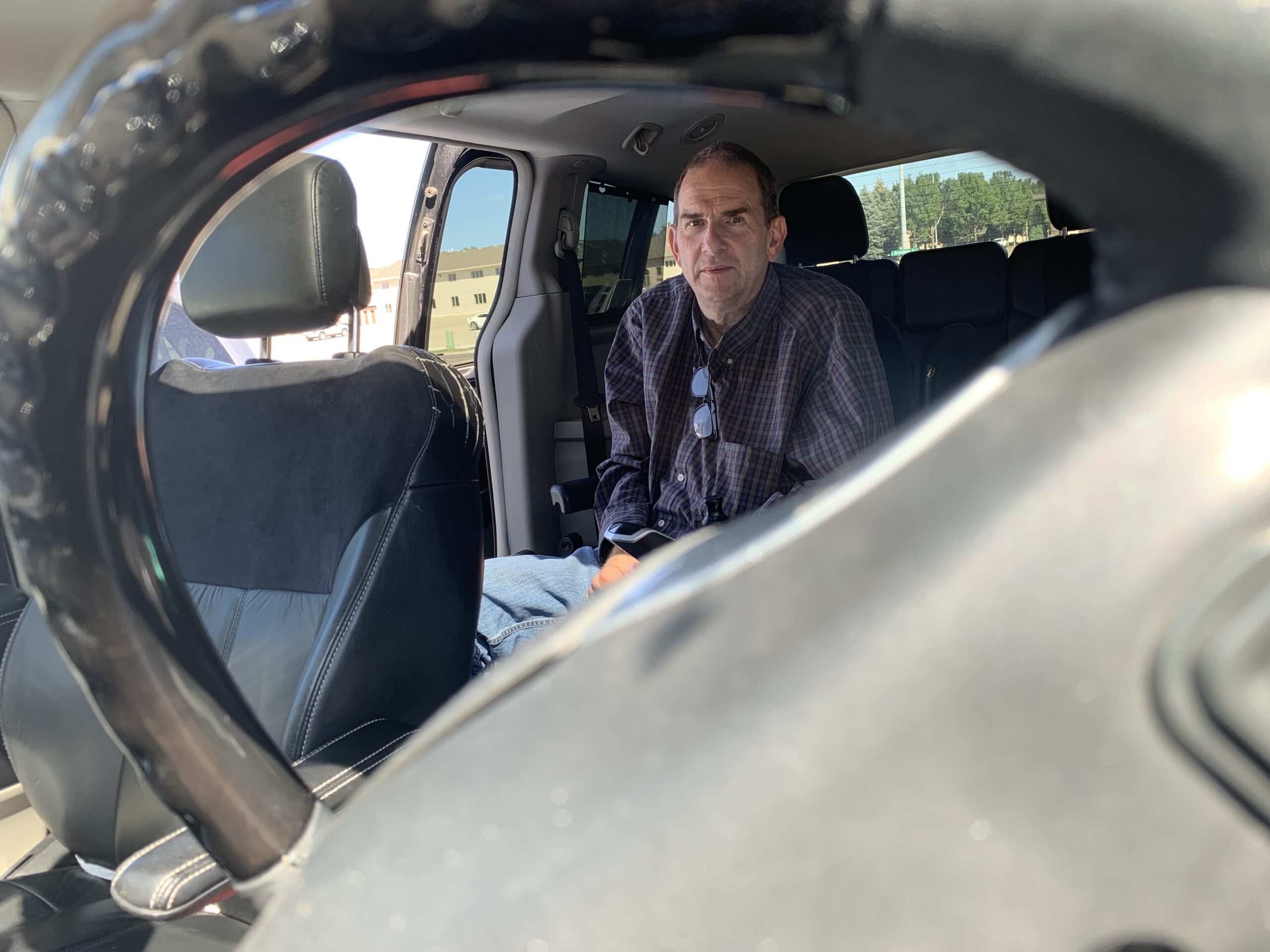 Royce inside his van. The photograph is taken through the steering wheel. He is in the back of the van where he will begin to transfer to the diver's seat.