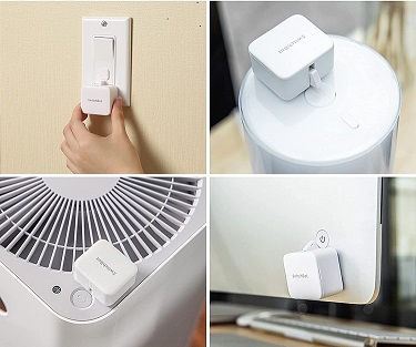 small square switch with robotic arm attached to a rocker light switch, another attached to a fan, another one attached to a computer and one attached to a coffee maker