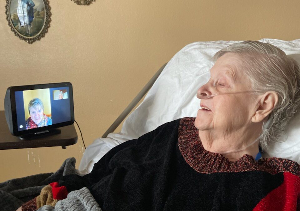 Grandma talking to daughter on Echo Show while laying in bed.