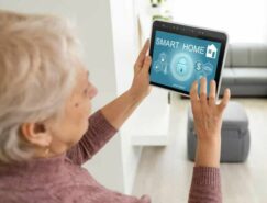 Older lady holding up tablet which shows Smart Home on screen