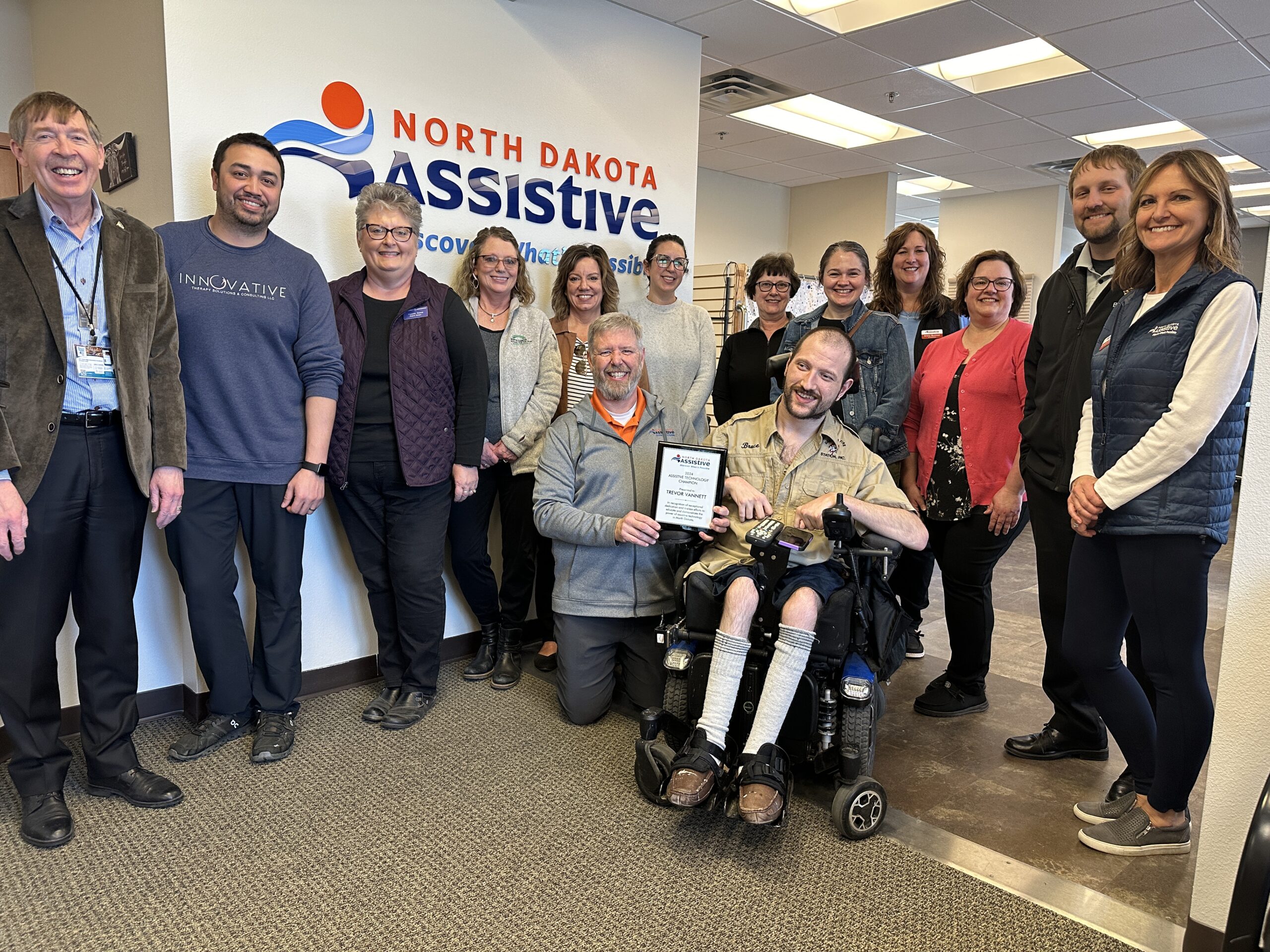 Friends of North Dakota Assistive gather in the Bismarck office to celebrate state and national Assistive Technology Awareness Day.