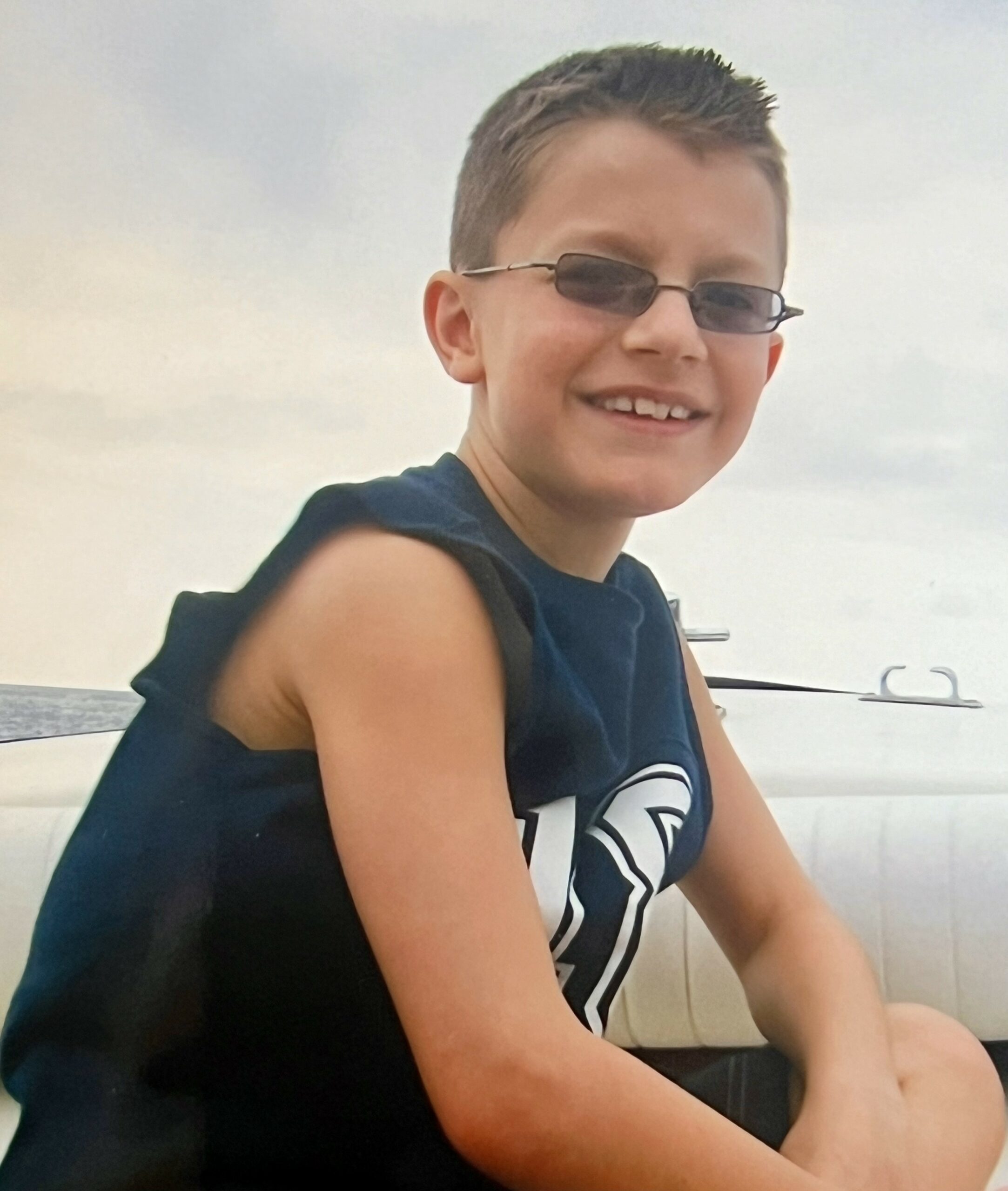 Paxton, age 8, smiling in front of the Atlantic Ocean.