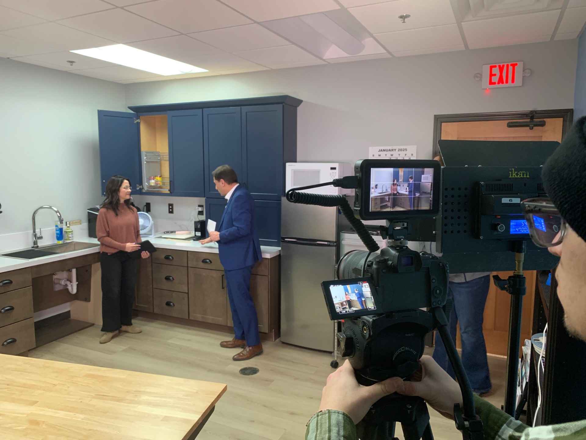 Tami Ternes demonstrates accessible kitchen shelving to Wayne Wolff of KFYR-TV.